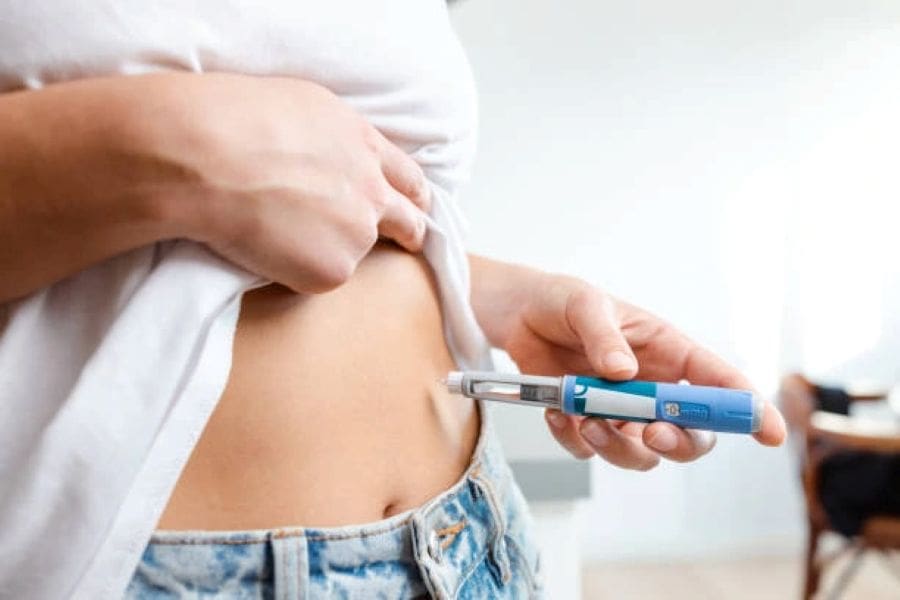 Woman injecting GLP-1 medication as part of a medically supervised weight loss maintenance plan