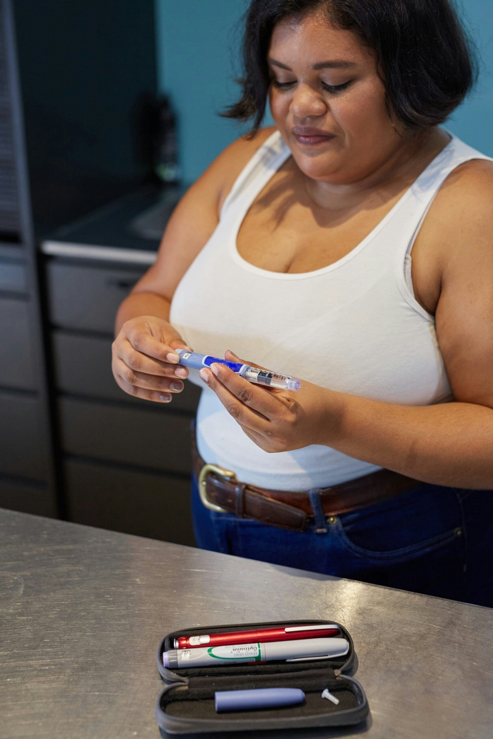 Patient preparing a GLP-1 weight loss medication injection pen used for obesity treatment