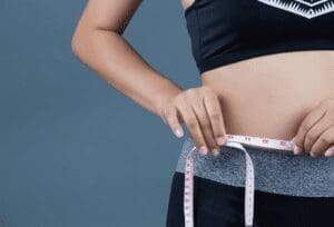 woman measuring waist for PCOS weight loss