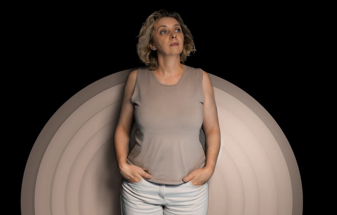 Woman experiencing perimenopause weight gain looking upward, representing midlife metabolism changes and hormone-related weight gain